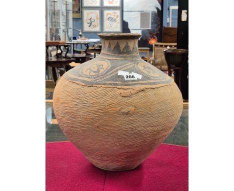 A Neolithic Chinese terracotta vase decorated in black on the shoulders with chevrons and roundels, the compressed spherical 