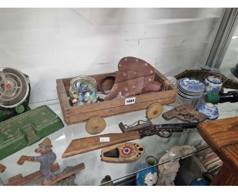 Toy guns, glass marbles, a child's blue and white coffee set, a toy spotlight, etc.