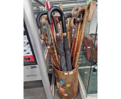 A flower painted stick stand together with walking sticks and umbrellas