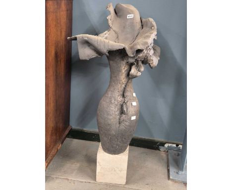A grey ceramic sculpture in the form of a flower, the flared petals on a tall ovoid stem resting on a cube plinth.   H 89cms.
