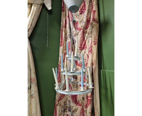 A three tier blue and white chandelier hung from two tiers of three chains