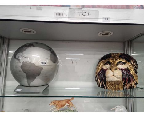 A lion mask together with an Italian terrestrial globe by 'Atmosphere' 