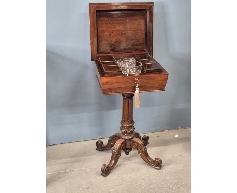 A 19th century rosewood teapoy, the lid opening to reveal four canisters flanking two glass bowls supported on a fluted colum