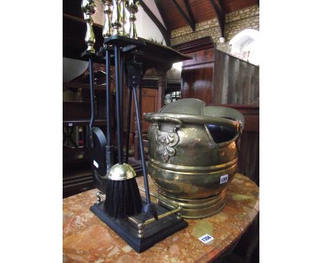 A 19th century brass coal helmet together with a steel and brass companion set