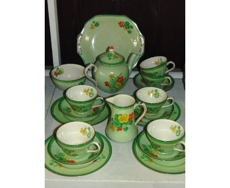 A collection of Booths Art Deco tea wares with printed and infilled Nasturtium decoration on a green and white speckled groun