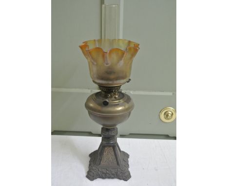 A Lampe Veritas, Victorian oil lamp with decorative cast iron foliate base supporting a brass font and burner with a tinted c