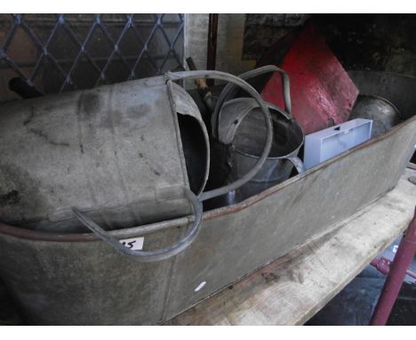 A vintage galvanised steel bath of tapered form together with two galvanised watering cans, small bucket, etc