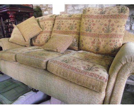 An Edwardian three seat sofa with scrolled arms and shaped back recently fully re-upholstered in flecked gold material, the c