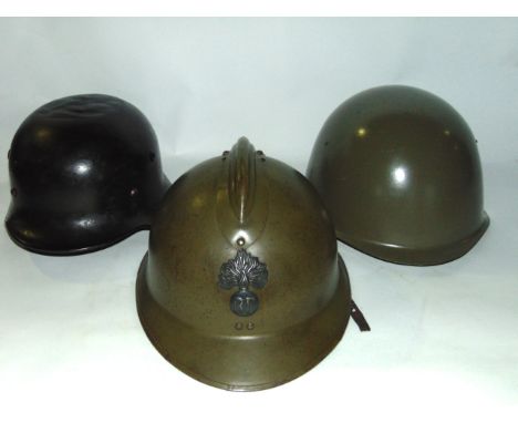 A Second World War German steel military helmet with all over blackened finish together with a later continental military hel