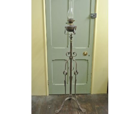An Arts and Crafts wrought and cast iron telescopic oil lamp standard, the central turned column supported by three organic s