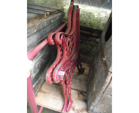 A pair of cast iron bench ends with decorative pierced foliate detail and painted finish