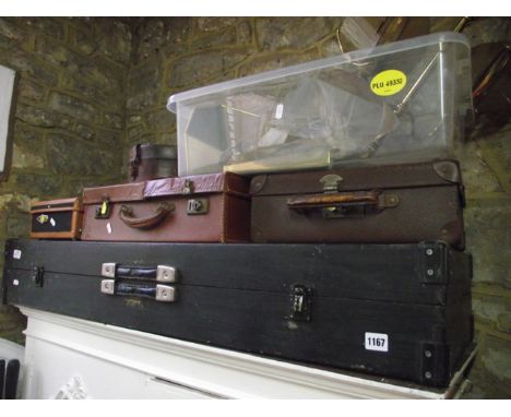 A collection of vintage suitcases and travelling boxes together with brass lighting and coloured shades