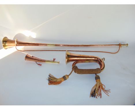 A good quality copper coaching/post horn with brass collars together with a similar short hunting horn and a similar military