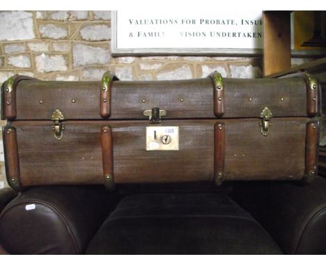 A canvas trunk with beechwood lathes and polished brass fittings