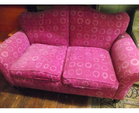 A Victorian upholstered sofa with shaped back and scrolled arms raised on turned supports with recently re-upholstered finish