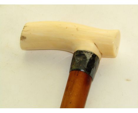 An antique Malacca walking stick terminating in a worked ivory handle