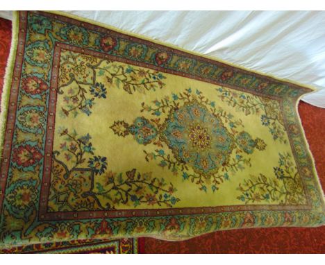 A Persian style wool runner with central medallion upon a pale fawn coloured ground with floral detail set within running bor