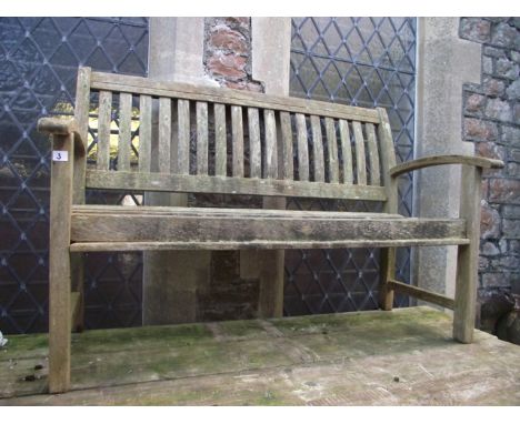 A weathered contemporary hardwood garden bench with slatted seat, back and curved arms, 140 cm long approx