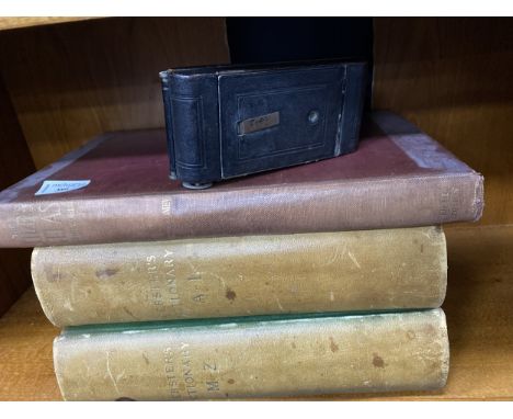 TWO VOLUMES OF WEBSTERS DICTIONARIES, along with another book and a vintage camera (4)