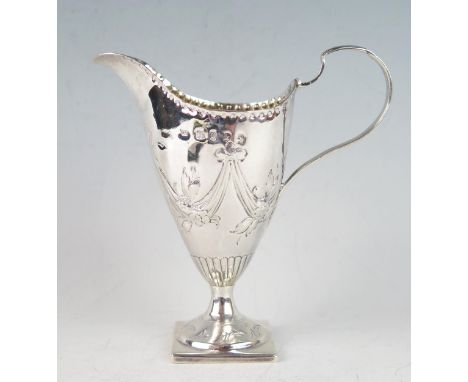 A George III silver cream jug, maker Charles Hougham, London, 1785, of helmet-shaped outline, with ribbon tied floral decorat