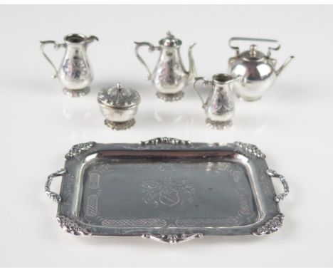 A sterling silver miniature rectangular tray, stamped sterling, crested, together with miniature coffee pot, two jugs, non ma