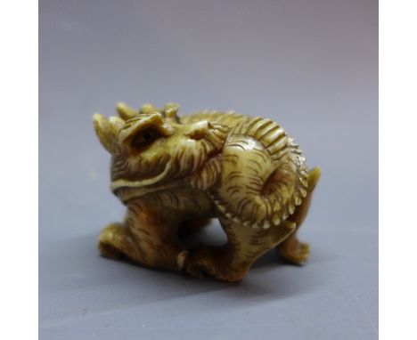 A Japanese ivory netsuke in the form of a dragon, signed. L.3.5cm 