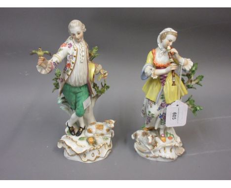 Near pair of 20th Century Meissen figures of a young man with a bird and a girl playing a recorder with sheep at their feet o