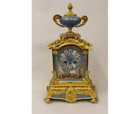 19th Century French ormolu mantel clock having porcelain mounts, the dial with Roman numerals and scene of figures in a lands