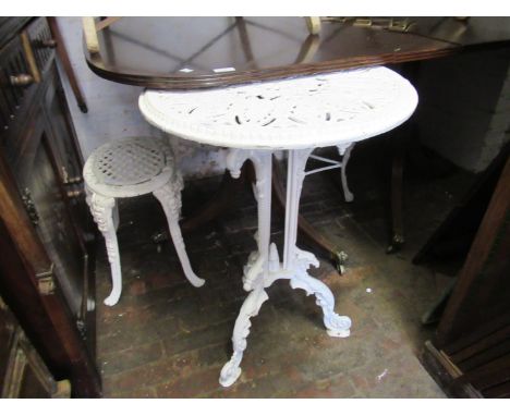 Small painted cast iron pedestal table with a tripod base, together with a small painted cast iron stool and a similar cast a