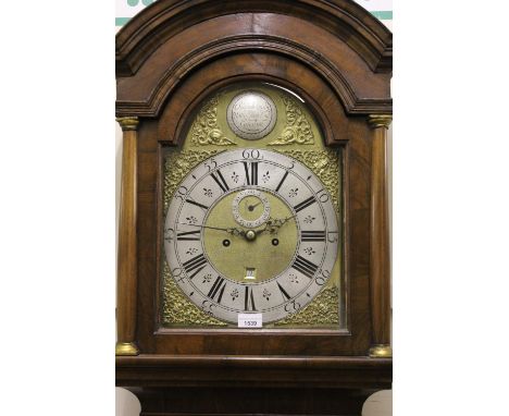 Figured walnut longcase clock, the broken arch hood with flanking pilasters above a moulded panel door and conforming plinth 