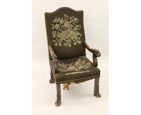 19th Century Continental oak open armchair, the padded back and seat covered in a tapestry style fabric, the arms carved with