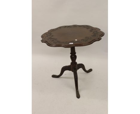 19th Century mahogany circular shaped edge tilt-top pedestal table, the floral carved top above turned fluted column and carv