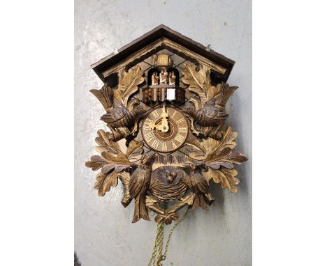 Mid 20th Century Swiss Black Forest three train cuckoo clock with carved surmount in the form of an owl, 23ins high excluding