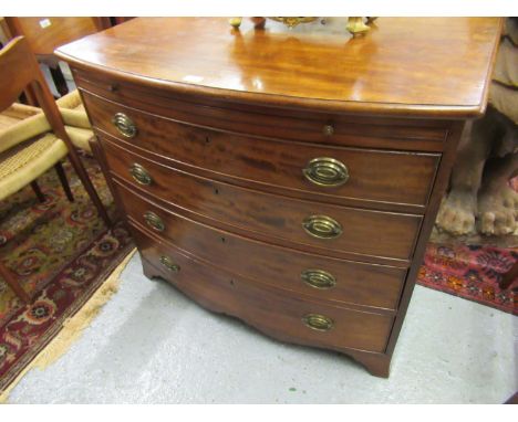 19th Century bow front chest, the moulded top above a brushing slide and four graduated drawers with circular brass ring hand