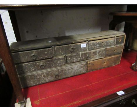 Small antique stained pine bank of drawers containing a quantity of miscellaneous itemsMiscellaneous items include tools, scr