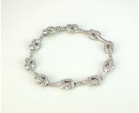 A diamond set stylised knot bracelet, attributed to Verdura, the articulated bracelet designed as ten diamond set stylised kn