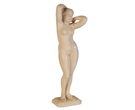 MANNER OF JOE DESCOMPS: A NUDE FEMALE IVORY SCULPTURE, standing nude, her hands holding up her hair behind her head, on a rec