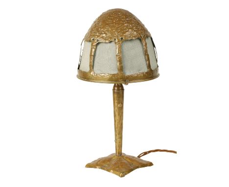 ARTS AND CRAFTS BRASS TABLE LAMP, the textured domed shade modelled in the form of a tree, the cut panels inset with green fa