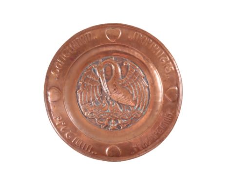 IN THE MANNER OF KESWICK: AN ARTS AND CRAFTS COPPER CHARGER, circular form, the centre embossed with a Pelican in her piety, 