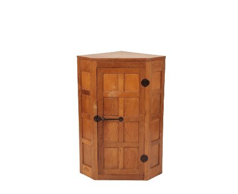 •ROBERT "MOUSEMAN" THOMPSON: AN OAK CORNER CUPBOARD, eight panel single door with traditional wrought metal hinges and latch 