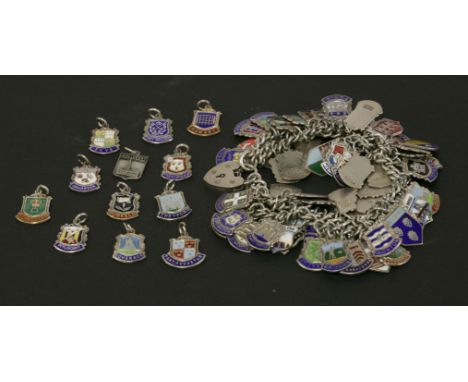 A silver charm bracelet, a quantity of silver enamel charms, and a collection of similar base charms