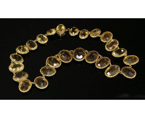 A late Victorian gold and citrine graduated riviere necklace, with a series of graduated oval mixed cut citrines, each citrin