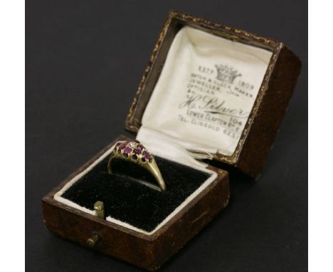 A gold diamond and ruby boat shaped cluster ring, tested as approximately 18ct gold