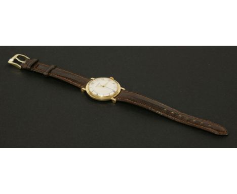 A gentleman's 18ct gold Jaeger Lecoultre mechanical strap watch, c.1955.  Circular case, 33mm diameter, circular ivory colour