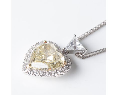 Bezel-set to the centre with a heart-shaped diamond weighing 5,01 carats, colour natural light fancy yellow, clarity I1, acco