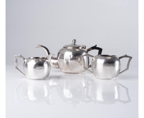 Comprising: a teapot, milk jug and sugar basin, each with reeded body, the tea pot with leaf-capped ebonised handle 13cm high