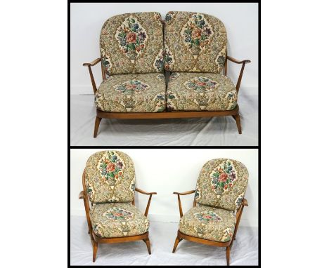 'ERCOL' CONSERVATORY SUITEdated 1980, comprising a two seater settee; and a pair of armchairs, with spindle backs, raised on 