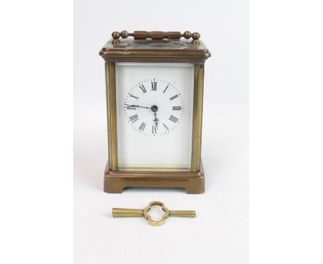 Brass Carriage clock with engine turned handle, bevelled glass and Roman numeral dial, with double ended key 