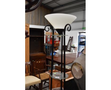 A modern uplighter standard lamp having glass shelved column