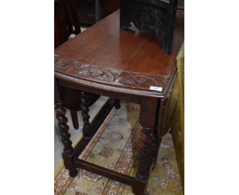 A mid 20th Century oak twist gate leg dining table with carved decoration